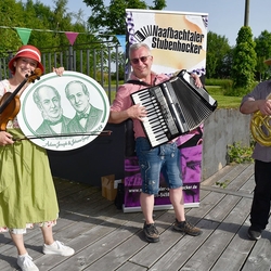 Die Naafbachtaler Stubenhocker in kleiner Besetzung: Reinhild Friedrich (Violine und Gesang), Axel Friedrich (Akkordeon und Gesang) sowie Uwe Kelter (Tuba). Mit ihrer Begeisterung für Volksmusik und kölsche Töne werten sie jedes Fest zu einem rhythmischen Vergnügen auf. Für das Breuer-Gedenken haben sie ihr Repertoire um Stücke aus dem Gesellenliederbuch von Johann Gregor Breuer sowie um Volkslieder der damaligen Zeit erweitert.