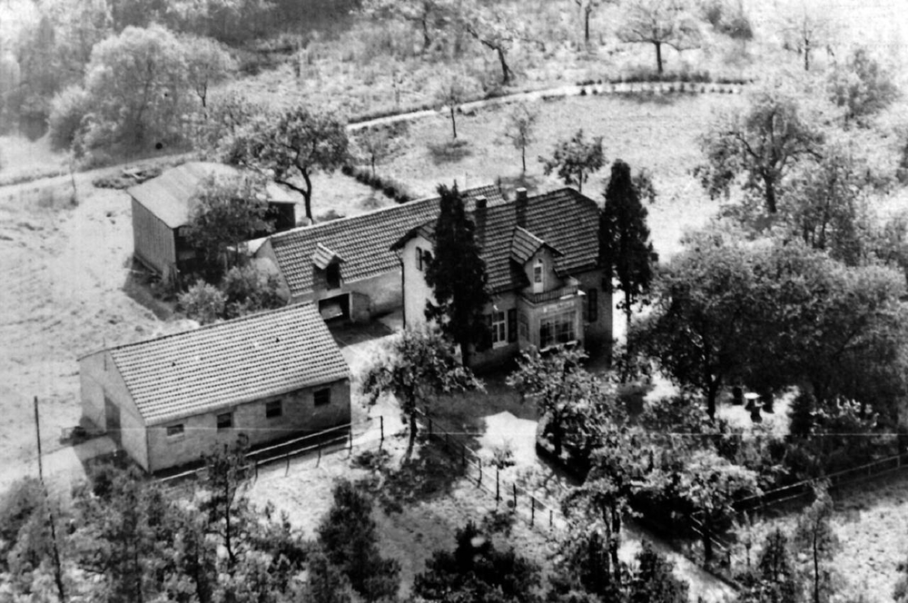 Haus Waldeck Mitte 1950er Jahre.
Bildmitte Wohnhaus, dahinter ein Anbau mit
Waschküche, Garage und Ställe für eine Kuh und ein Schwein, dahinter eine Scheune; links im Bild der Pferdestall 