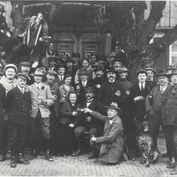 Männerchor Wahlscheid hilft beim Umzug von Fam. Breideneichen nach Auelerhof. Von links: 1. Max Fischer, Haus-Dorp; 2. Heinrich Breunsbach, Schuhmacher, Aggerhof; 3. Paul Fischer, Haus-Dorp und Hoffnungsthal 4. sitzend: Frau Hugo Breideneichen 5. sitzend: Hugo Breideneichen 6. knieend: Emil Weber, 1. Vorsitzender des Männerchores, Aggerhof 7. hinter 6. stehend: Gustav Hohn, Aggerhof 8. hinter dem Hund stehend: Hugo Fischer, Lebensmittel, Aggerhof 9. Hermann Schiffbauer, Gastwirt, Auelerhof 10. Gustav Schönenberg „Wieße“ Briefträger, Aggerhof 11. Paul Lemmer, Neuhonrath
2. Reihe: 1. mit Mütze heller Rock: Karl Weber, Auelerhof 2. mit Schlägermütze-dunkler Rock: Hermann Lindenberg, Müllerhof 3. ? 4. mit Mütze-eine Körperhälfte verdeckt: Wilhelm Steeger, Müllerhof 5. Friedchen?(Anna) Breideneichen 6. ? 7. Willi Hohn, Auelchen und Auelerhof 8. nur mit Oberkörper-heller Hut: Rudolf Kiel, Schiffarth 9. nur mit Kopf: Erwin Piel, Wahlscheid
hintere Reihen:schräg hinter der Dame mit Mütze u. weißem Hemd: Fritz Wilhelms (?), Auelerhof
vorletzte Reihe links – neben dem Kind – mit weißem Hemd: Karl Ober- dörster, Elektriker, Auelerhof
vorletzte Reihe Mitte – mit Zigarre im Mund: Karl Schiffbauer, Gastwirt, Auelerhof
vorletzte Reihe rechts – neben den beiden Damen – mit Hut: Karl Lindenberg, spät. Vorsitzender des Männerchores, Weeg neben dem Baum-vor den Kindern: Heinrich Naaf, Münchhof ganz hinten-mitten vor der Tür: Gustav Koser, Aggerhof
im Baum ganz rechts: Hugo Radermacher, Kreuznaaf; im Baum ganz links: Emst Frackenpohl, Weeg; im Baum Mitte: Rudolf Lindenberg, Münchhof
am Baum rechts-Kind: Emst Bergfelder, Müllerhof
