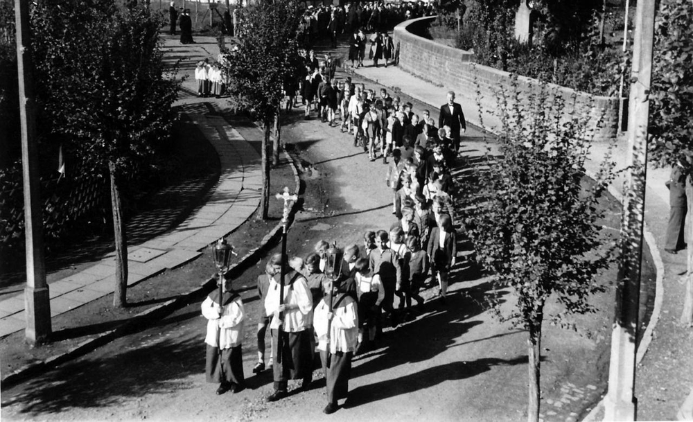 Sakramentsprozession 1945/46, Kirchstr. vor dem Haus Postertz. Josef Klug (mit Kreuz), dann  Schulkinder-Jungen mit Lehrer Schmitz (Anzug). Oben links: eine Gruppe Meßdiener, die darauf wartet, eingegliedert zu werden.