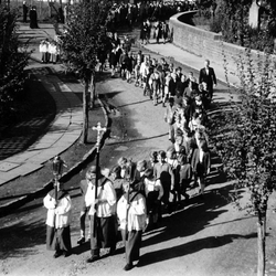 Sakramentsprozession 1945/46, Kirchstr. vor dem Haus Postertz. Josef Klug (mit Kreuz), dann  Schulkinder-Jungen mit Lehrer Schmitz (Anzug). Oben links: eine Gruppe Meßdiener, die darauf wartet, eingegliedert zu werden.