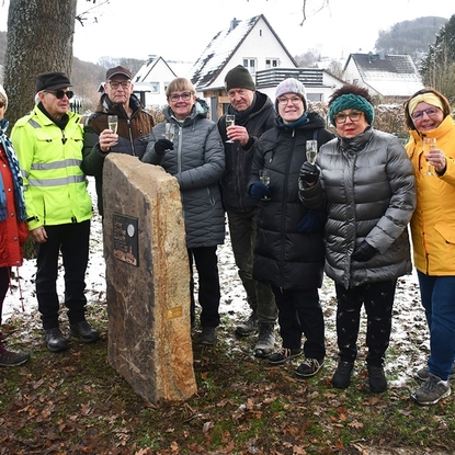 (von links) Doro und Paul Hoeher, Klaus und Cäcilia Obermierbach, Steinmetz Markus Weisheit, Michaela Röhrig, Gitti Bäcker-Gerdes und Ulrike Clever freuen sich über das sichtbare Zeichen ihres Sieges am Eingang von Neuhonrath. Foto Heinz Lenz