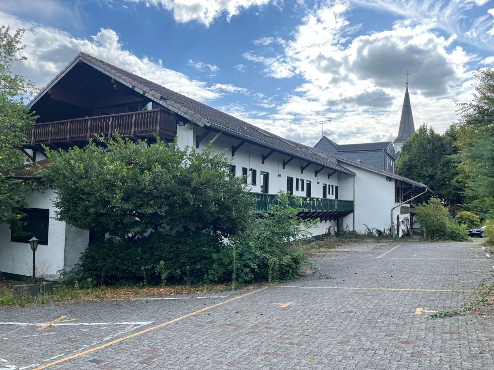 Aggertalhotel und Gasthof "Zur alten Linde" mit Kirche St. Bartholomäus im Hintergrund im August 2026